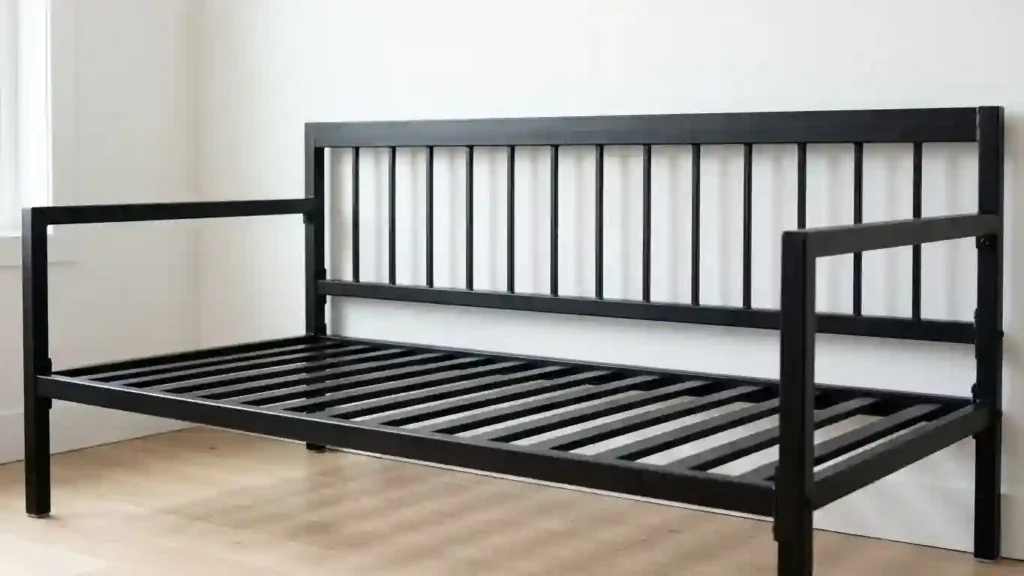 Black metal daybed frame showing back panel and side arm construction