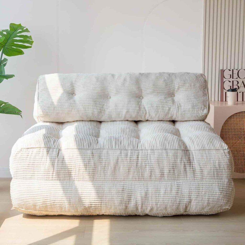 MAXYOYO folding floor sofa in beige shown as a seat and flat as a bed